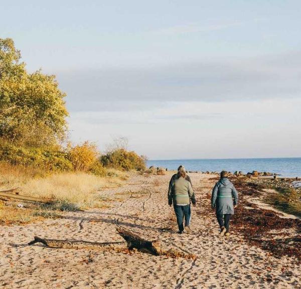 Turister går tur på stranden ved Teglværksskoven