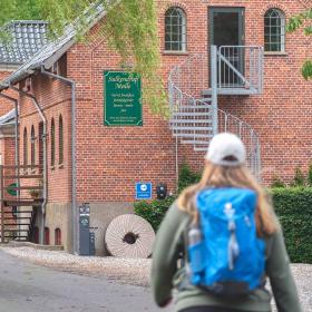 Ein Wanderer geht an der malerischen Sulkendrup-Mühle vorbei